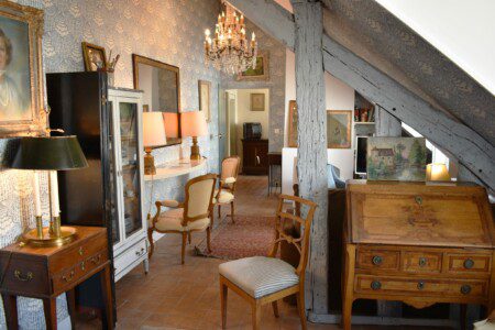 Warm lamplight, golden drapes and antique furniture that tells a centuries-old story — the sitting room of this Luxury studio Rue Saint-Honoré Paris 1st wraps you in the timeless atmosphere of a grand Parisian residence, where every detail speaks of a refined and deeply personal art of living, just steps from the Seine.