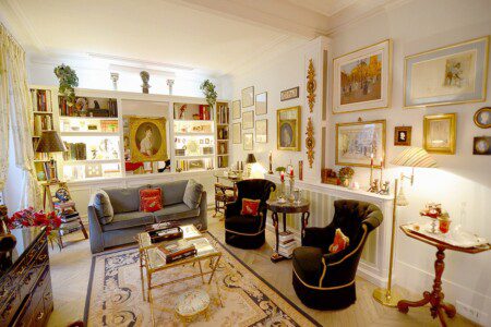 Luxury family apartment near Eiffel Tower Paris – library living room with grey sofa and gilt frames