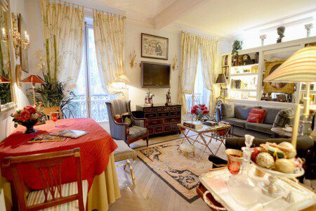 Luxury family apartment near Eiffel Tower Paris – living room with red round table and golden curtains