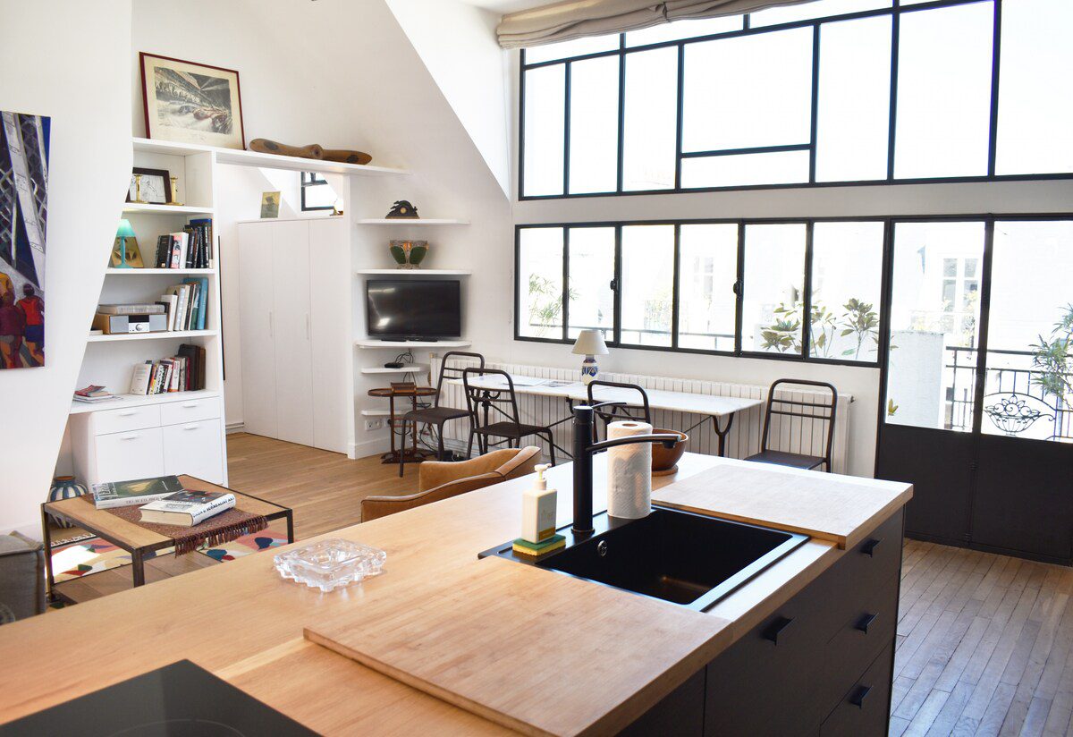 Artist loft Paris – open-plan kitchen and living room with atelier windows