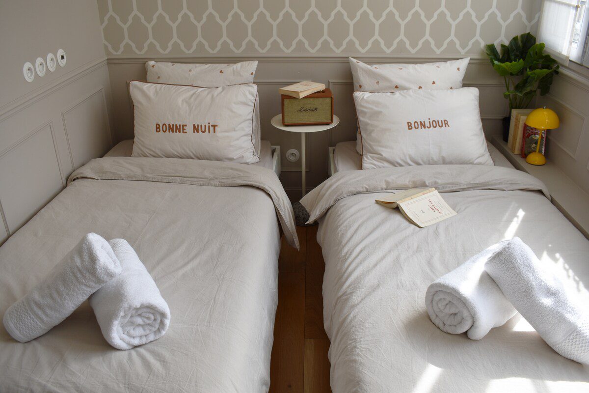 Luxury apartment near Parc Monceau Paris – bedroom with embroidered pillows