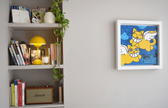 Luxury apartment near Parc Monceau Paris – bookshelf with yellow cat artwork and lamp