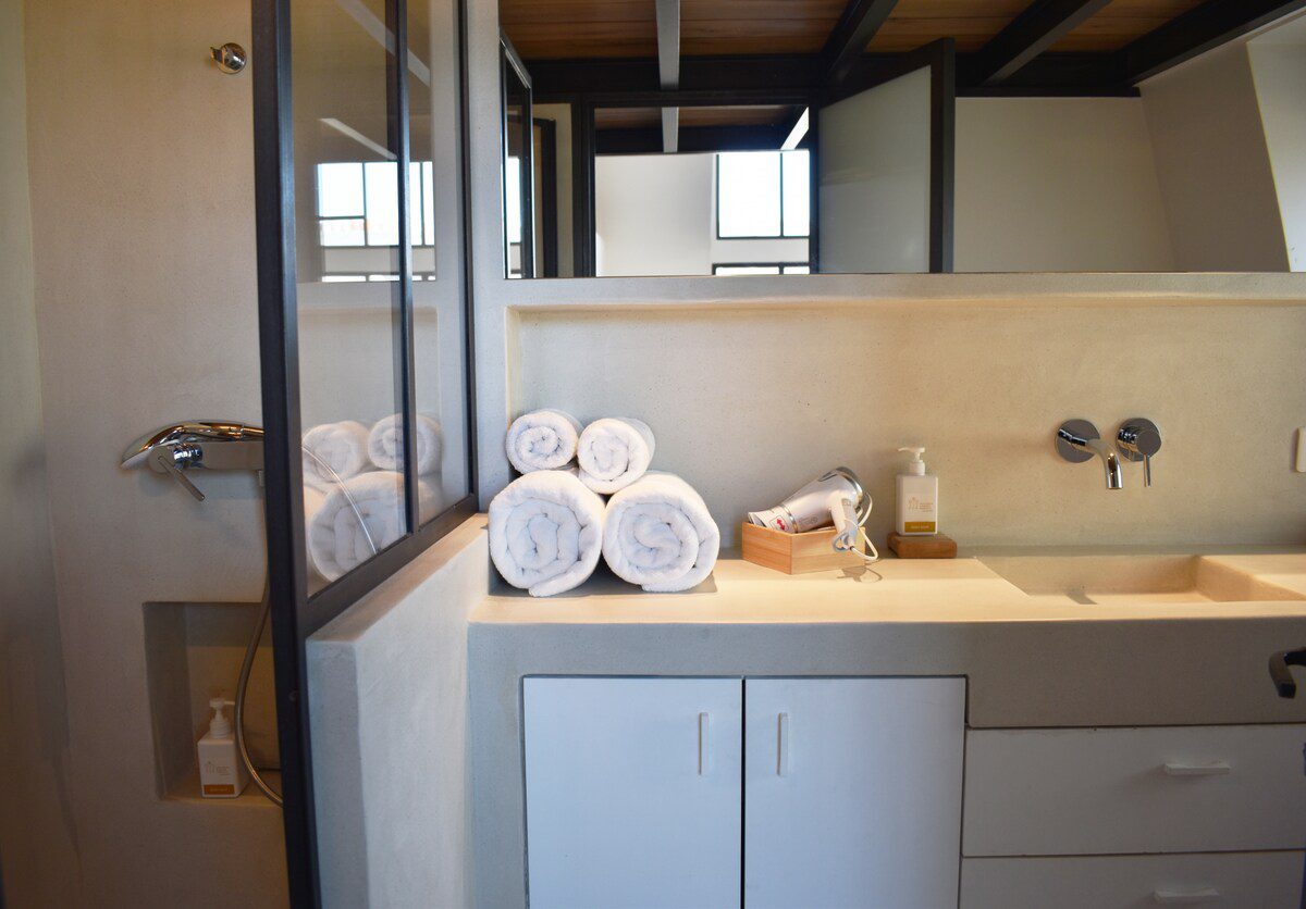 Artist loft Paris – bathroom vanity with rolled towels and concrete sink