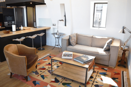 Artist loft Paris – lounge area with sofa, armchair and patterned rug